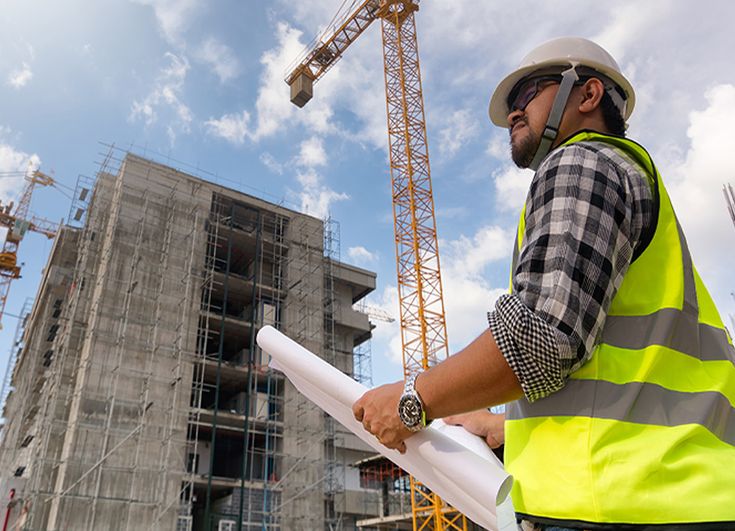 Construction site engineer reviewing plans at a building project
